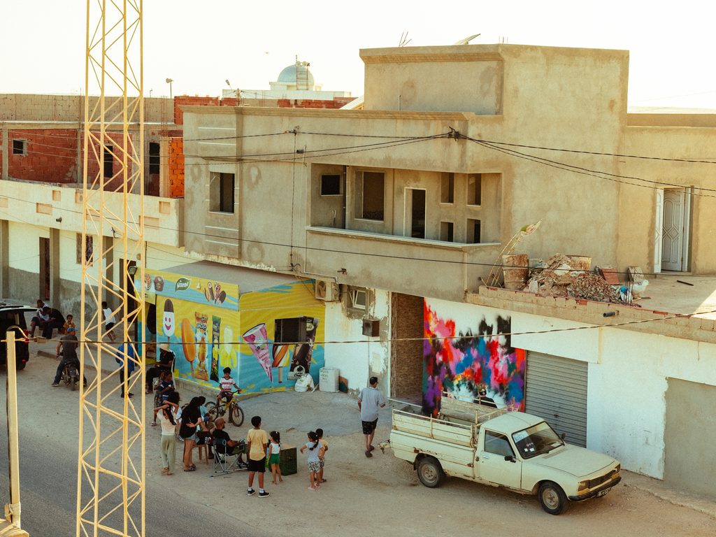 Contemporary street art and cultural collaboration in the olive-growing landscape of southern Tunisia.